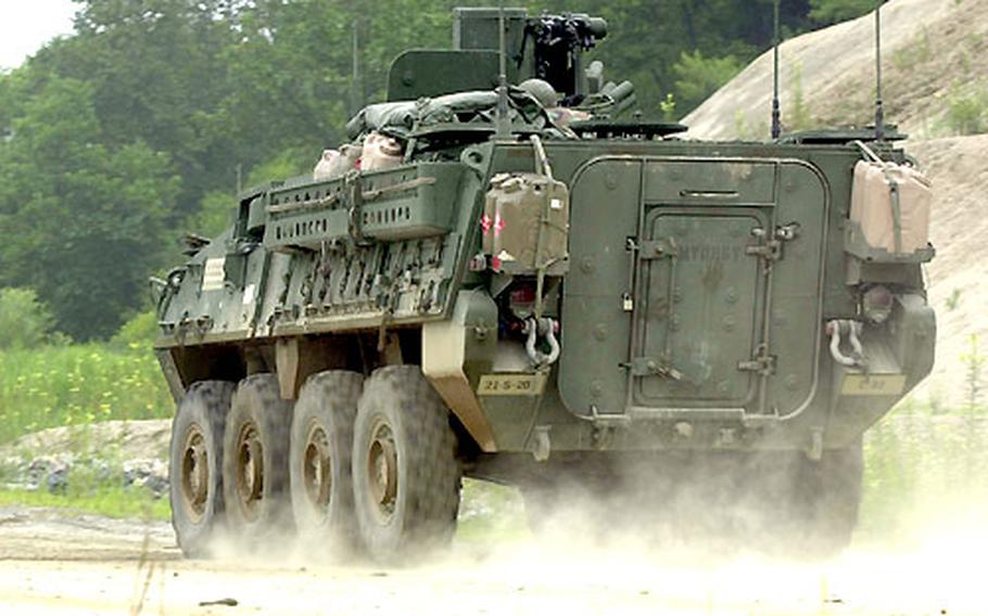 A Stryker armored personnel carrier rolls down a dusty lane at Rodriguez Range.