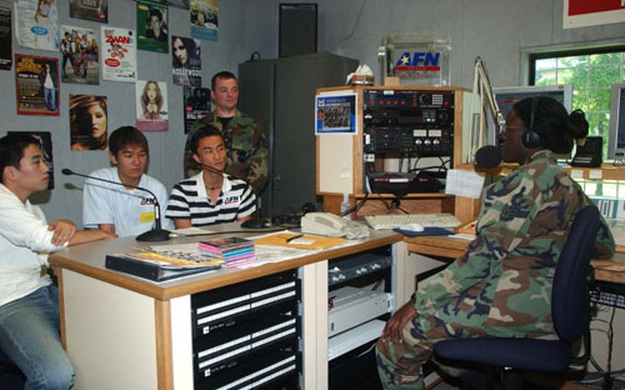 Staff Sgt. Davinia Seay, Armed Forces Network broadcaster, gives Staff Sgt. John Goolsby, 8th Operations Support Squadron, and shadow students (left to right) Mr. Yi, Woo Taek, Mr. Yi, Ju Heon, Howon University and Mr. Kim, Jong Bong, Kunsan University, the opportunity to be disc jockeys for a day at the AFN studio at Kunsan AB today.