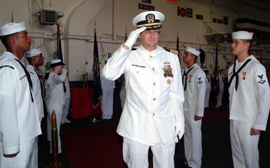 Capt. Jan M. van Tol passes through the traditional sideboys during the recent change of command ceremony for the USS Essex held in the ship's hangar bay. Capt. van Tol relieved Captain Ronald R. Evans as skipper during the ceremony attended by about 200 sailors and guests.