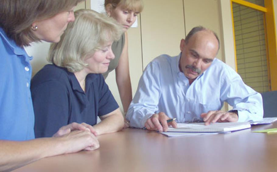 Russ Claus decides on scheduling and calendar preparation prior to the start of the school year with Amy Fuller, registrar, next to Claus, Katie Chaney, administrative assistant, in the middle, and Joyce Wakefield, office manager.