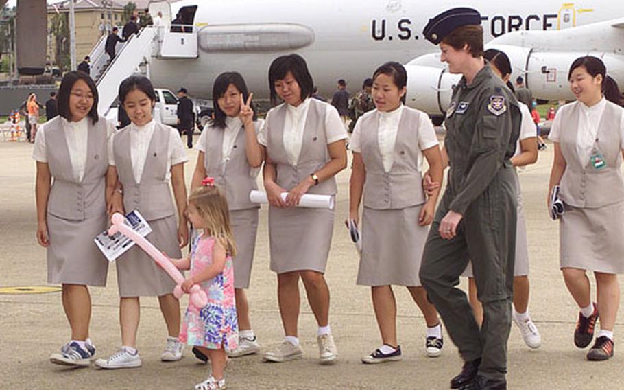 As a U.S. servicemember looks on, a group of South Korean students enjoys last year's Osan Air and Space Power Day. The event happens again Sunday.