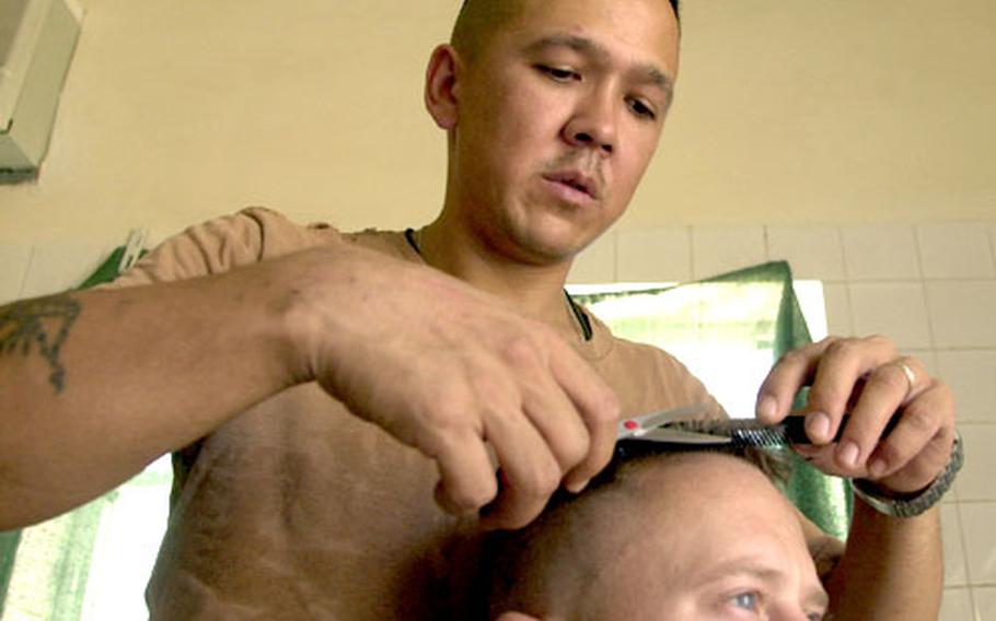 The hands of a surgeon, the confidentiality of a psychiatrist: Staff Sgt. Joseph Chapman does some tonsorial fine-tuning as he finishes up work on Capt. Joe Murdock, 855th Military Police Company.