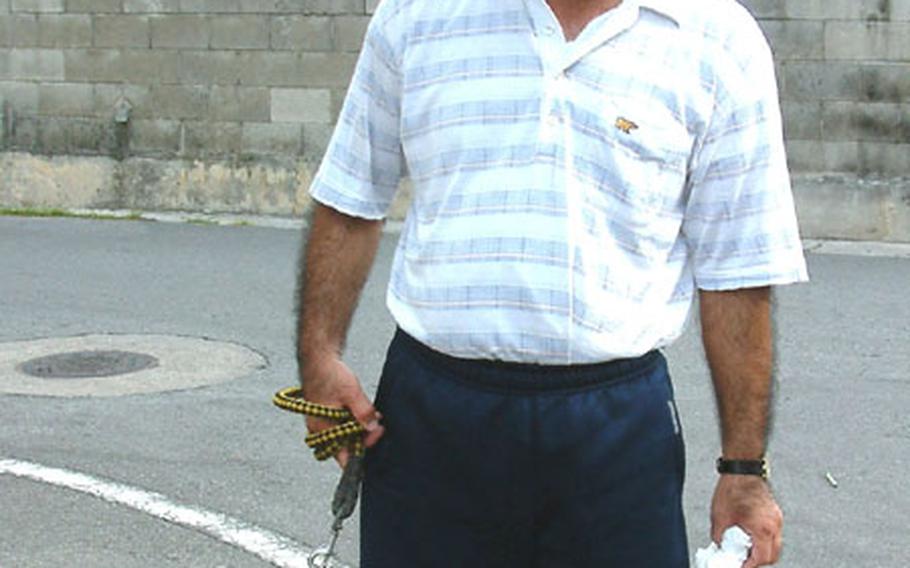 Masanao Miyazato, 53, a postal worker, took his dog, John, for a long walk in the park while his neighborhood was evacuated Saturday morning during the defusing of rocket-propelled grenades in Naha.