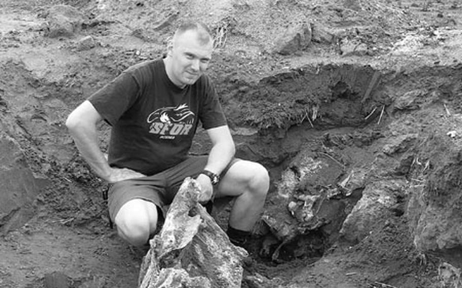 Army Staff Sgt. Danny Keay displays aircraft remains found at the crash site of a World War II Thunderbolt plane near Griesheim, Germany.