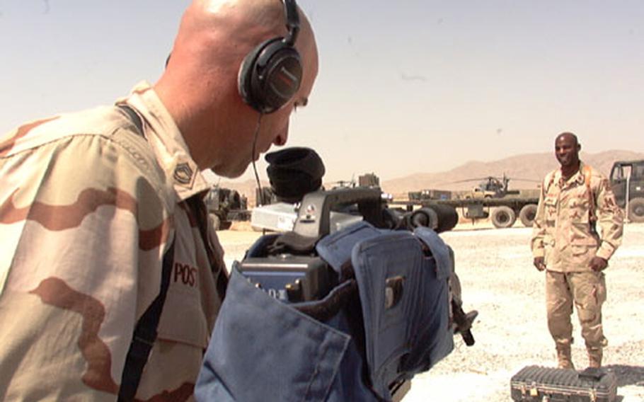Sgt. 1st Class Jamie Posten, left, records a holiday greeting for Staff Sgt. Marvin Washington, Sunday at the air base in Kandahar. Washington recorded two messages, for family members in Maryland and South Carolina.