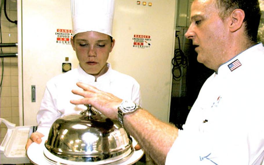New Sanno Hotel Executive Chef Putnam Yost checks the roasted duck leg one last time before James Vagasky delivers it to his dinner guests at hotel Saturday.