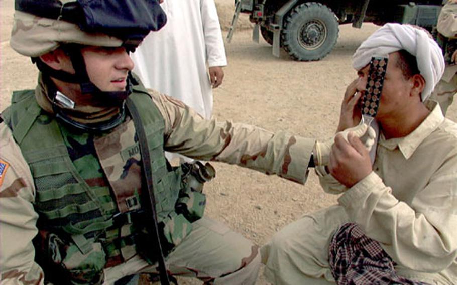 Optometrist Capt. Jason Moyer gives an eye exam to a young patient Tuesday in Raibi Kalasha, Afghanistan. The optometry clinic at Kandahar Airfield can make glasses for the villagers and send them out with civil affairs teams, Moyer said.