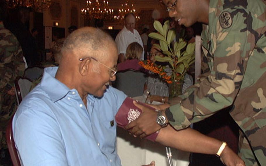 Spc. Landis Rush, 21, of Sacramento, Calif., checks retired Sgt. 1st Class Harry Jeffries' blood pressure Saturday at Patrick Henry Village in Heidelberg, Germany. About 500 people attended U.S. Army Europe's 23rd annual Retiree Appreciation Day.