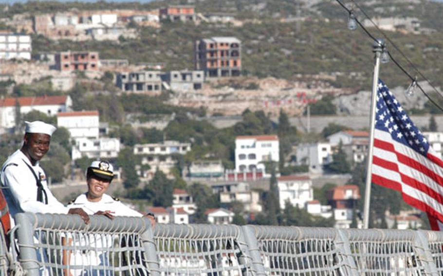 A couple of sailors aboard the USS Nicholas flight deck chat on Friday. In their background is the Bosnian coastal town of Neum. Nicholas is the first foreign ship to anchor in the Bosnian waters of the Adriatic Sea since a 1914 visit by an Austro-Hungarian vessel.