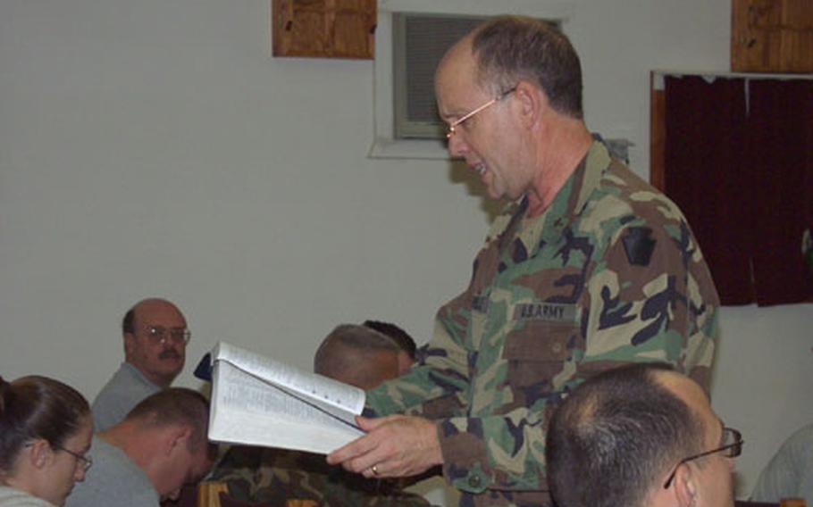 Chaplain (Maj.) Bruce David Farrell, of the 28th Infantry Division, Division Artillery, reads a verse out of the Bible Wednesday in a chapel on Camp Bondsteel, Kosovo. The verse related to a 25-minute historical video on the odyssey of the apostle Paul. Students must attend eight classes in order to go on a retreat following in Paul's footsteps through Greece.