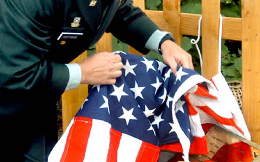U.S. Army Maj. Barry Hoffman unveils a plaque in New Alresford during a ceremony Friday. The plaque honors Capt. Robert W. Cogswell, who guided his crippled B-17 away from the town 60 years ago.