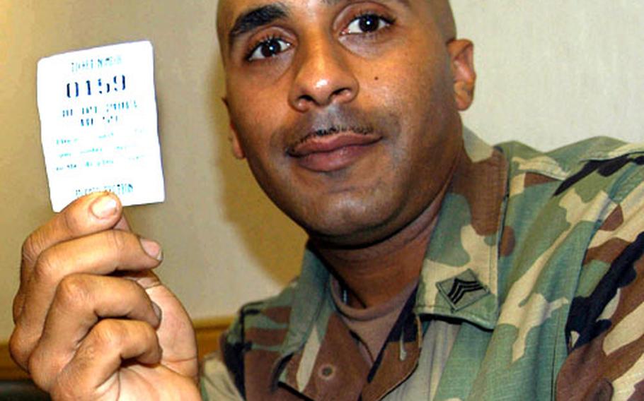 Sgt. Raymond Rossi, a soldier stationed at Camp Kyle, shows his number in line for a new ID card Tuesday at Yongsan Garrison. Rossi still was waiting around 4 p.m. even though his number was marked 10:59 a.m.