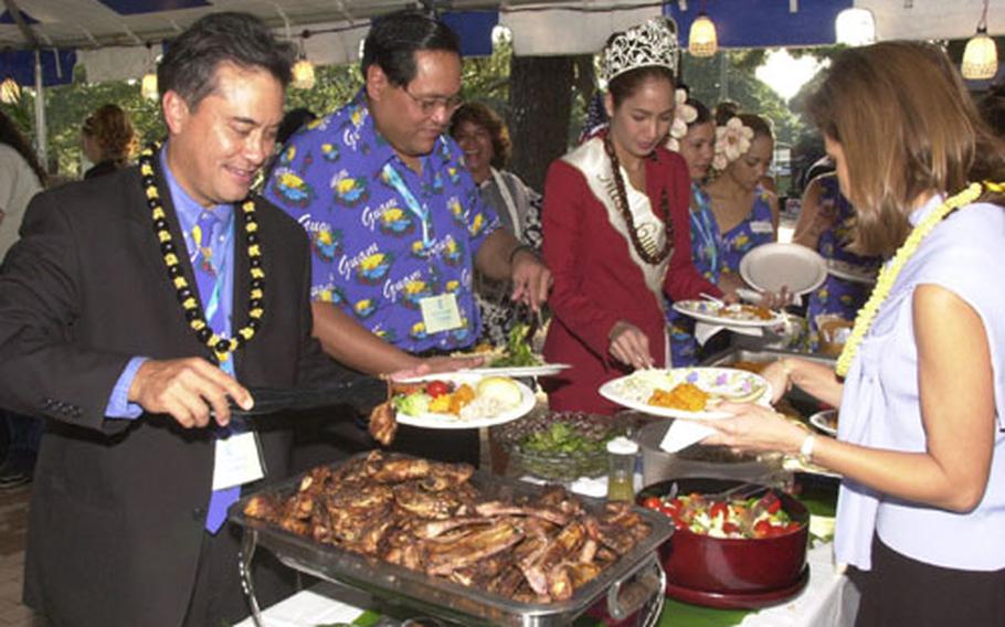Felix Camacho, Governor of Guam, places some traditional Chamorran food on his plate during a visit to Camp Zama's Dewey park, Thursday. Camacho, visited with Kanto Plain servicemembers from Guam while returning from a Pacific tour promoting tourism to Guam.