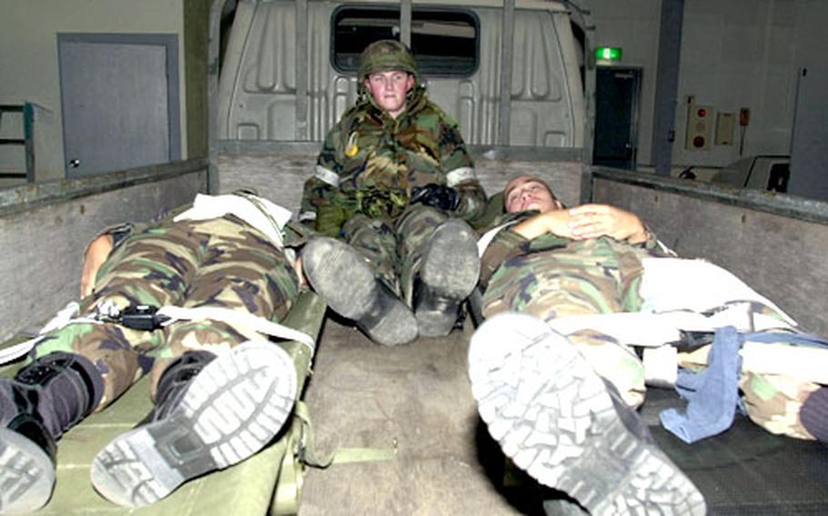 Airman Joshua Nyenhius waits for transport in the bed of a pickup with "victims" Airman Basic Natasha Bowen and Airman 1st Class Brian Carroll during the exercise at Misawa.