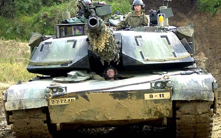 The crew of Red 1, a tank with Company B, 2/72 Armor, prepares to move into battle position before a mock engagement.