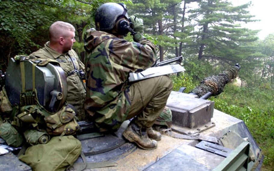 Sgt. Jason Kreiling, left, and 1st Lt. Jason Hanson, of B Co., 2/72 Armor, try to spot advancing enemy armor units.