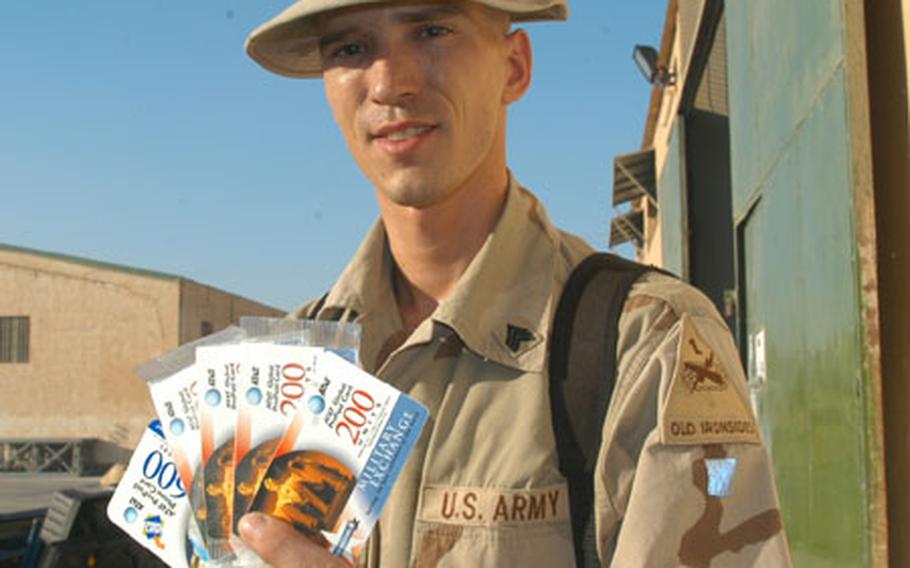 Sgt. William Bernal of the 47th Forward Support Battalion holds up the stack of phone cards he carries with him in case he has the opportunity to call his wife in Germany or family in the United States. Bernal's family sends him either Wal-Mart or Sam's Club phone cards from home and he also purchases cards from the Baghdad International Airport exchange. He gets more talk time per dollar from the AAFES cards.