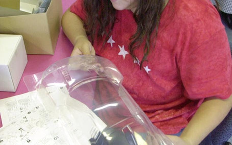 Anissa Hooper, 11, takes an initial look at the remote controlled race car mold she and her teammate will make into a screaming race machine as part of Sasebo Naval Base's MWR Youth Recreation programs.