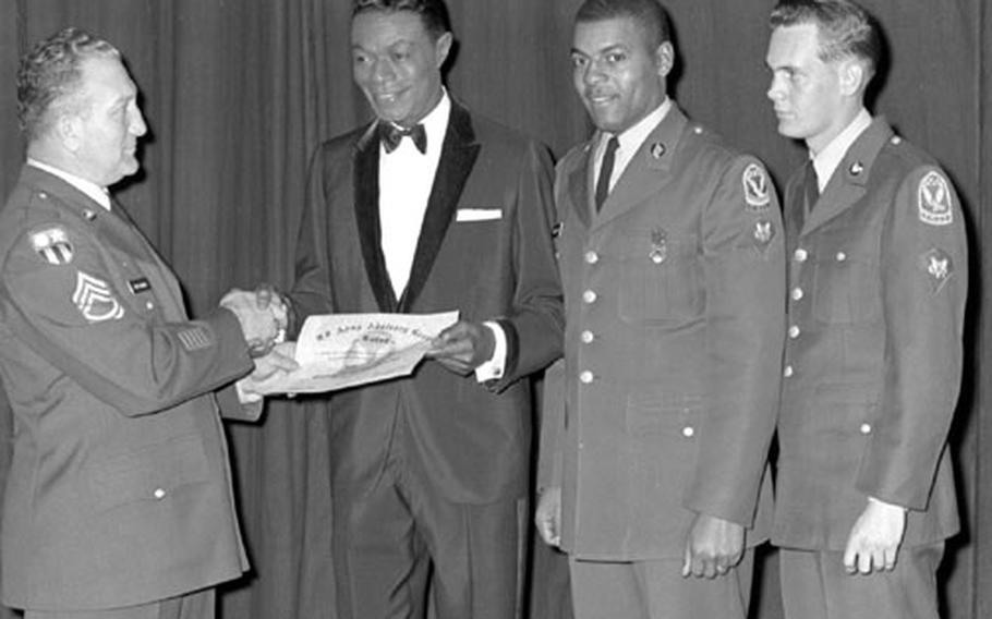 Nat King Cole is presented with a certificate making him an honorary Army recruiter.