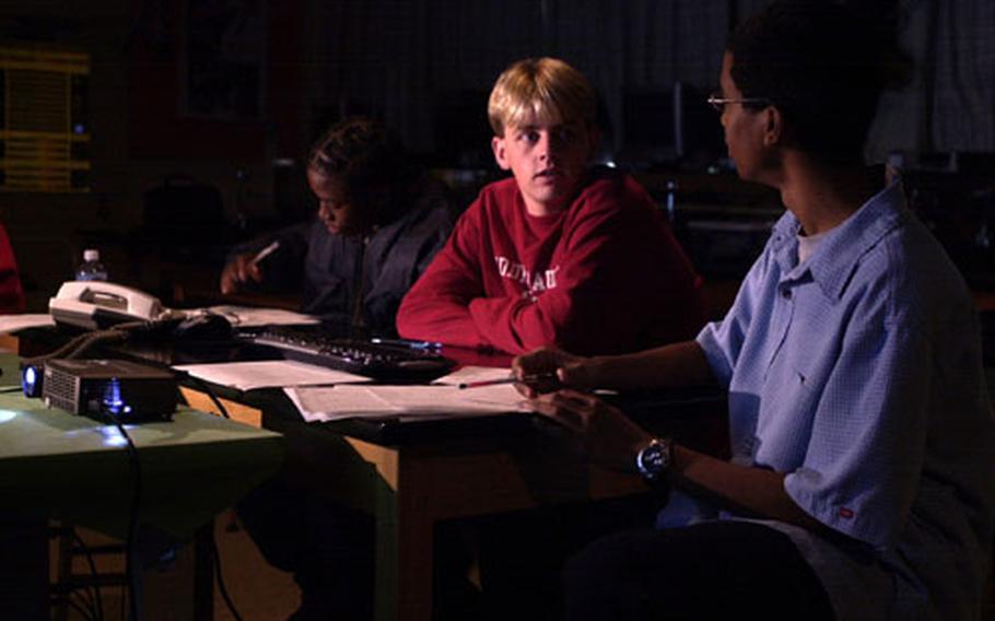 Thaddeus Reap, left, records data while Nicholas Ziegler, center, talks with Phillip Clark during the students' time controlling the Goldstone Apple Valley Radio Telescope in Apple Valley, Calif. The three students are juniors at Kubasaki High School on Okinawa and were the first students to take part in the GAVRT program at the high school.