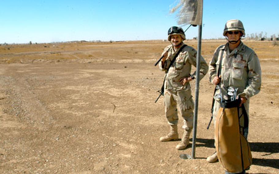 Master Sgt. Rick Brown, left, and Sgt. 1st Class John Bohonek stand at the ninth hole of the 229th Engineer Company’s golf course, UXO 9, at Camp Speicher. The unit built the nine-hole course over two days in July, after Brown drew up the design.