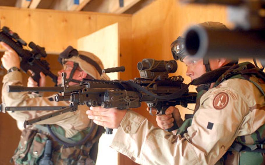 Spc. Jeremy Brown, 22, a SAW gunner from Broken Arrow, Okla., left, and Spc. Charles Ellett, 22, a rifleman from Riverton, Utah, clear a room for possible enemies during Movement on Urban Terrain training with other members of the Old Guard deployed to Camp Lemonier in Djibouti.