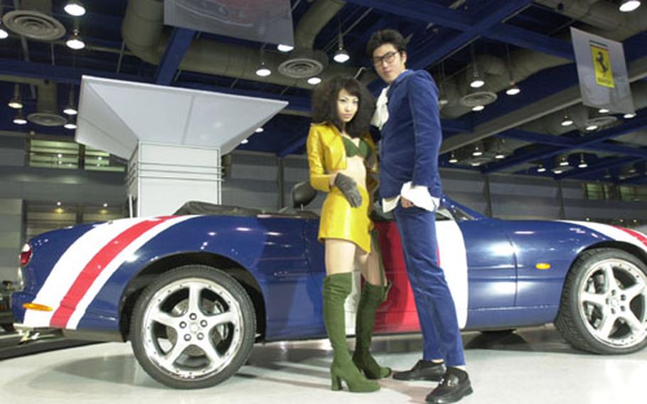 Models stand near Austin Powers' famed "Shaguar." The sportster is one of 53 cars on display at the Hollywood Motor Show at the COEX convention center in Seoul, a cool showcase of famous cars that runs through Sunday.