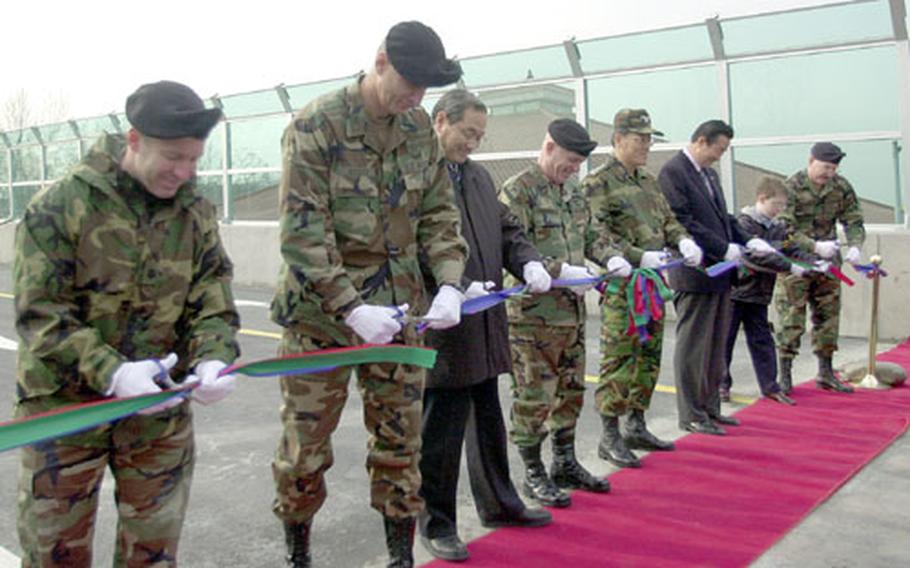 Dignitaries cut the ribbon before the new Yongsan Garrison overpass is opened to the public. Officials say the overpass will greatly reduce traffic both on and off base.