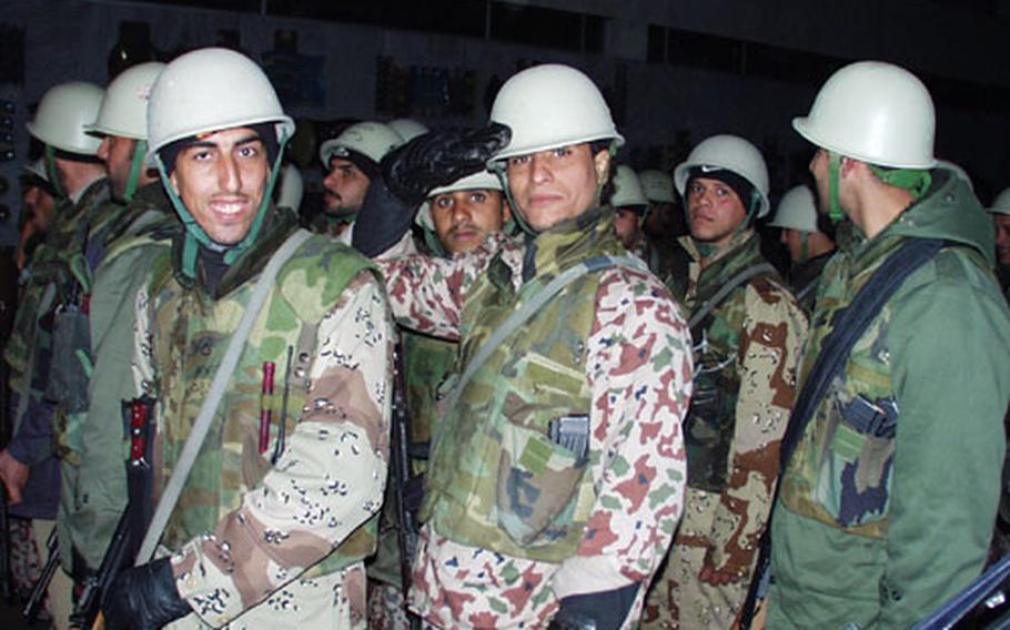 A member of the Iraqi Civil Defense Corps salutes before an evening raid.