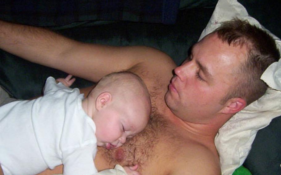 Home on leave from Iraq, Staff Sgt. Robert Foreman, 27, takes a nap Oct. 15 with then-4-month-old son Branden.