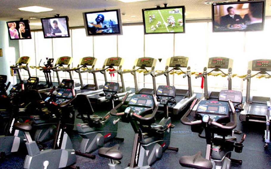 While working out at Yokosuka Naval Base, Japan, people now can enjoy a new cardio theater system that allows exercisers to plug in and watch any of five large-screen televisions.