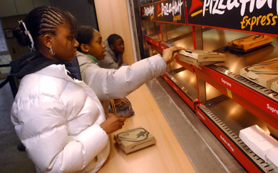 Youngsters from Wiesbaden American Middle School grab some personal pan pizzas from Pizza Hut in Wiesbaden, Germany, on Tuesday.