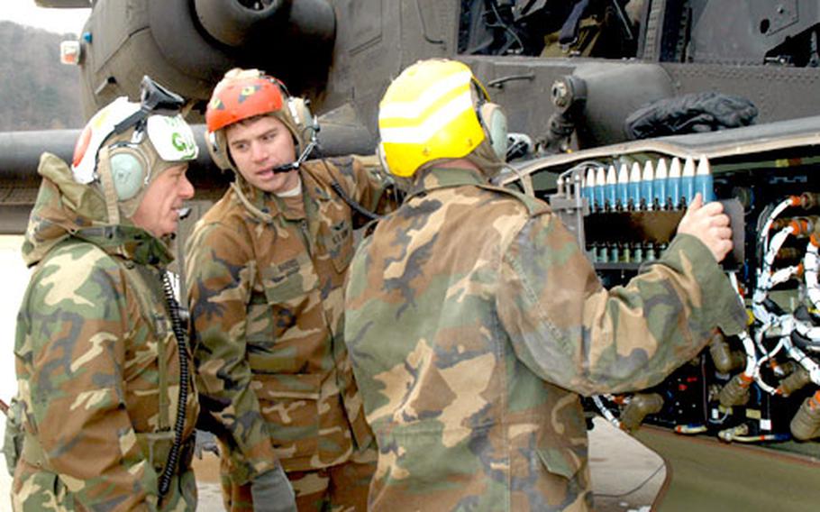 U.S. Forces Korea Commander Gen. Leon Laporte gets some pointers from Spc. Sean Harris, while Spc. Jesse Martin loads a chain of ammo into an Apache Longbow helicopter at Rodriguez Range on Monday. Company A of the 1st Battalion, 2nd Aviation Regiment was honored by LaPorte for four years of continuous flying without a serious accident.