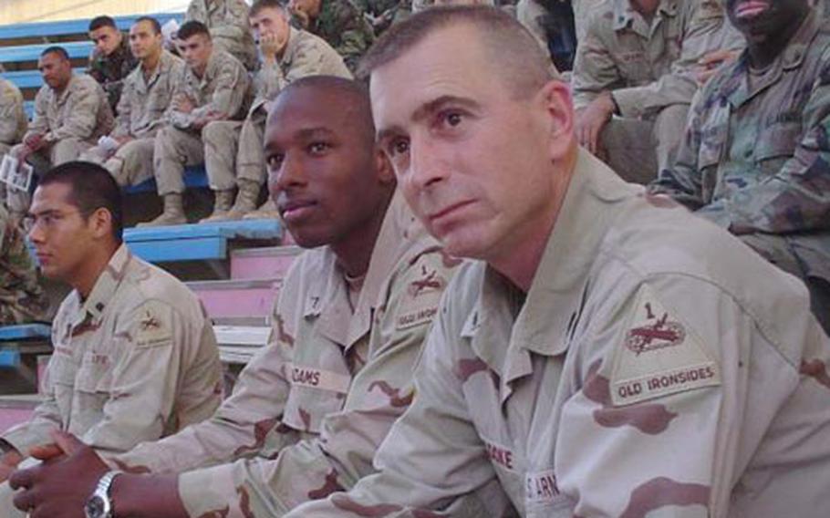 Command Sgt. Maj. Eric Cooke, foreground, of the 1st Armored Division's 1st Brigade, watches an event with soldiers in Iraq. Cooke was killed on Christmas Eve in Baghdad.