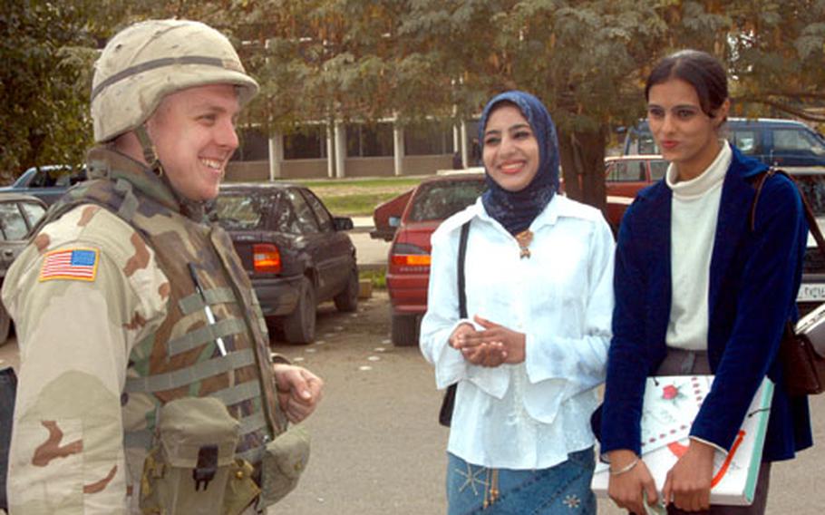 Pfc. Justin Bellatti, 25, of Wichita, Kan., chats with two Baghdad University students, Evaan and Juana, last week on campus.