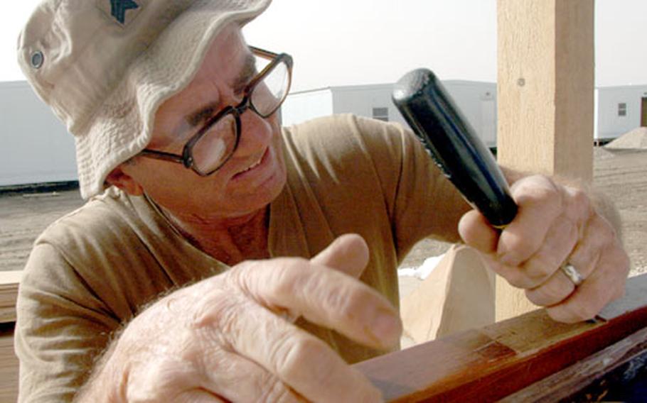 Using only a chisel, Sgt, Bruce Hofman, 58, of Webb City, Mo., gouges out a place to hang a door hinge.