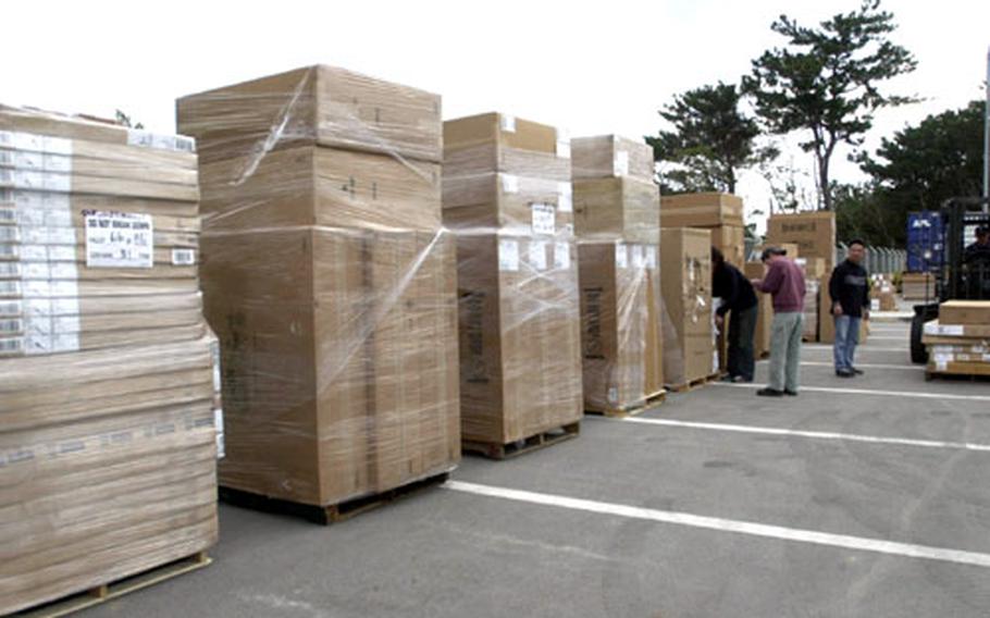 Okinawa District school supply personnel organize two truckloads of supplies received for the first-, second-, and third-grade classes on Okinawa.