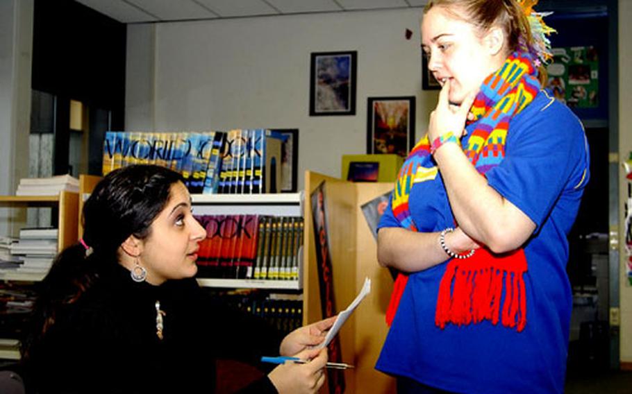 Marina Flevo-Tomas, left, and Lauren Capshaw, students at Ansbach High School in Germany, discuss Capshaw's resolution for their assigned country of Angola.