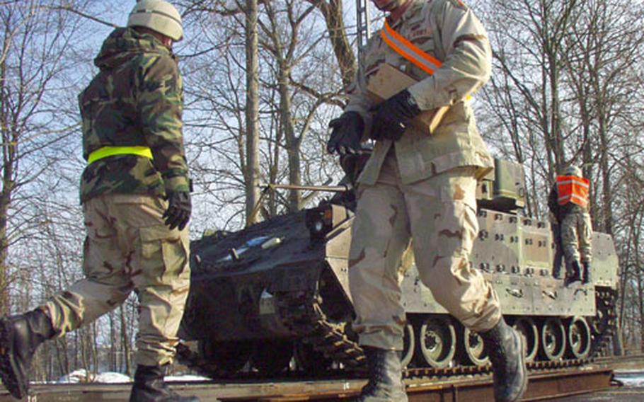Soldiers from the 1st Infantry Division's 1st Battalion, 26th Infantry load tracked vehicles aboard railroad flatcars Friday at Conn Barracks in Schweinfurt, Germany. The division is shipping about 7,000 vehicles to Iraq for use by its 12,000 soldiers in Operation Iraqi Freedom during the coming year.