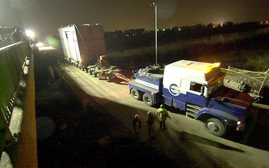 U.S. Army Corps of Engineers move a 300-ton generator across the Tigris River on Monday night in Baghdad. When brought online, the generator will increase the city’s power output by about 30 minutes daily.