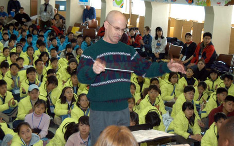 Chief Warrent Officer William Brazier conducts the 2ID band during a concert for young English language students at Everland on Friday.
