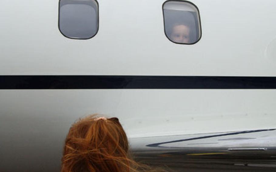 Amanda Kappler, 5, looks up at her brother, Dane Kappler, 2, peering from inside a C-21 Lear Jet, Monday at Ramstein Air Base.