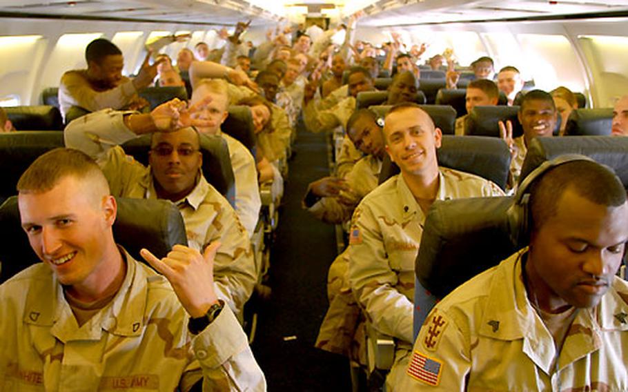 Soldiers from the 94th Engineer Battalion pose during their flight from Kuwait to Germany. Some of the troops are among the first to complete a full 365-day tour in Southwest Asia.