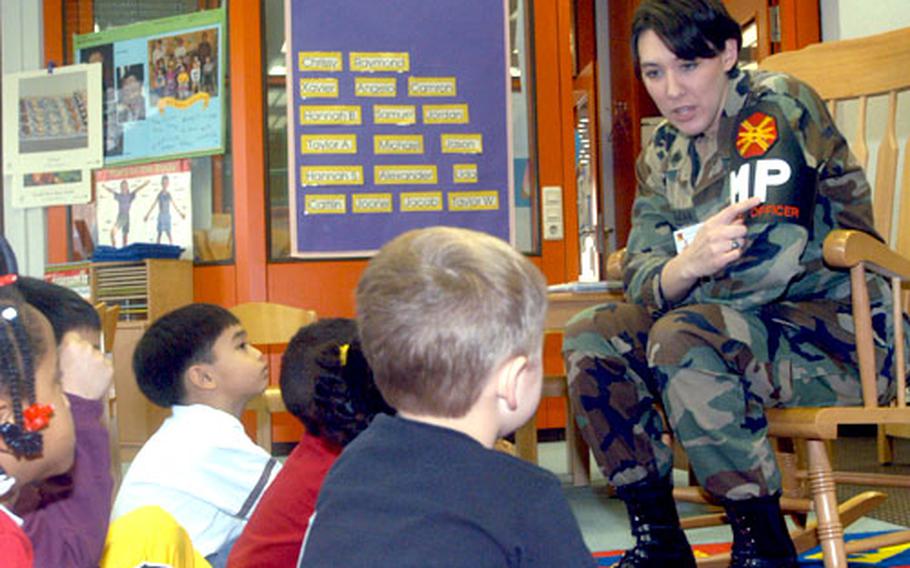 Amanda MacLean, a Drug Awareness Resistance Education officer from Wiesbaden, Germany, shows kindergartners on Rhein-Main Air Base how to spot a military police officer. MacLean began educating children at Rhein-Main, Wiesbaden and Dexheim on safety and other D.A.R.E. issues Tuesday.