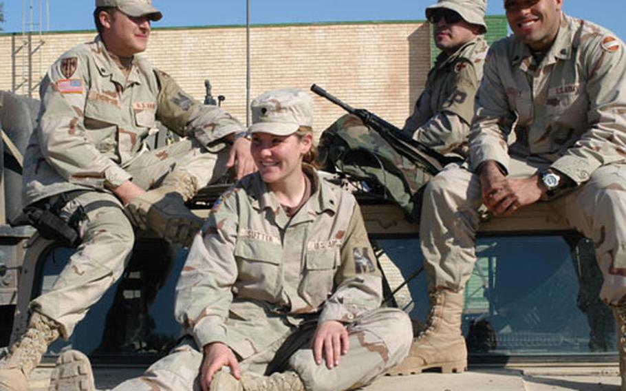 In military police units, male and female soldiers work together. Here, members of the 233rd Military Police Company, a National Guard unit from Springfield, Ill., relax on top of their Humvee. From left are: Spc. Michael Thompson Jr., Spc. Janet Sutter and Sgt. Richard Carroll. Spc. Ommy Frizarry, right, is with the 519th Military Police Battalion from Fort Polk, La.