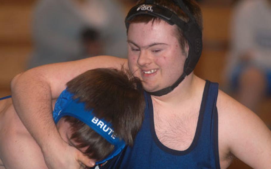 John Schaeufele of Lakenheath High School puts a hold on Kevin Nicholson of Brussels American High School during a wrestling meet at Alconbury High School. Schaeufele competes on the varsity team despite having Down syndrome.