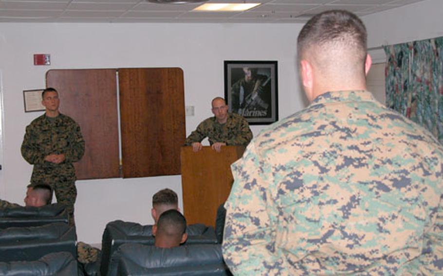 A member of Marine Corps Security Forces Europe at Rota Naval Station, Spain, explains what he learned about Combat Conditioning to Capt. Timothy Drake, left, and Staff Sgt. Phillip Wyman.