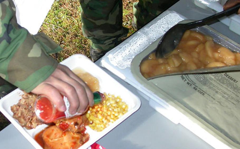 The Remote Unit Self Heating Meal (RUSHM), or "Kitchen in a Carton," provides everything needed to feed up to 18 troops in one tidy package. Dinner is served on a small tray during a technical demonstration at Fort Lewis, Wash., in December.