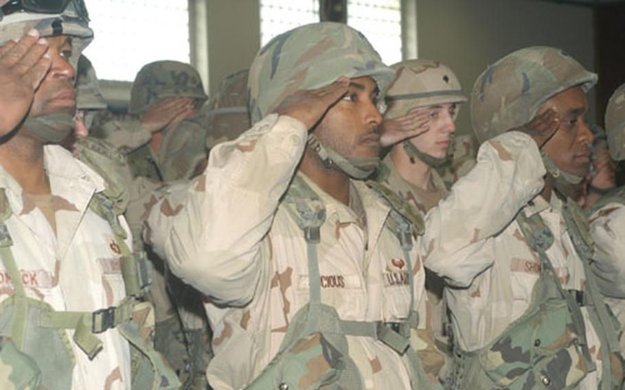 Troops from Company C, 32nd Signal Battalion, salute to the national anthem as they arrive home from a yearlong deployment from Iraq.