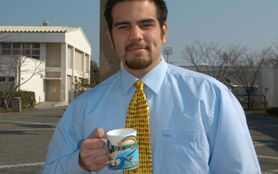 Ryann Hopp, 19, is a substitute teacher at Kinnick High School, from which he graduated last June. His tie and coffee mug denote authority.